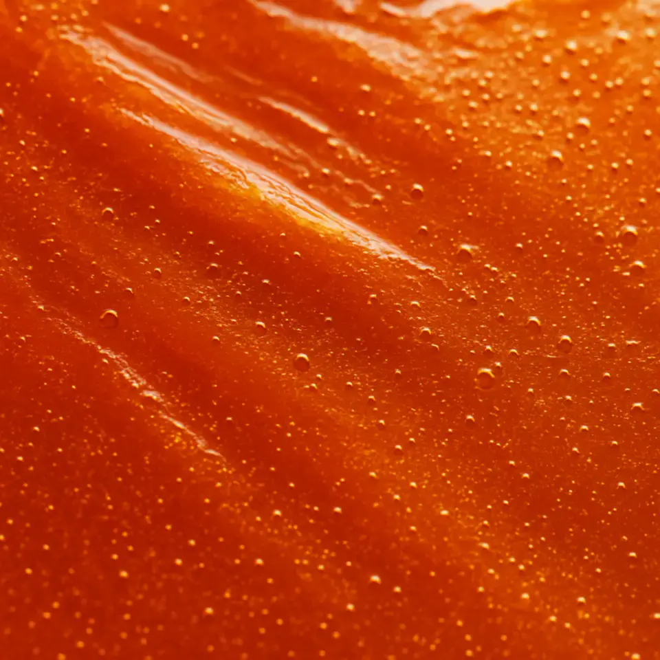A macro photograph showing the rich, deep orange texture of sea buckthorn oil