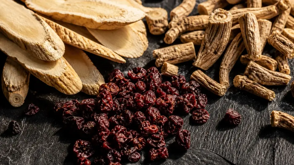 A Rustic Slate Platter Scattered with Dried Red Schisandra Berries and Astragalus Slices