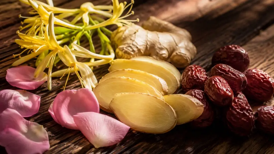 A Rustic Wooden Platter with Fresh Ginger Slices, Honeysuckle Flowers, and Rose Petals